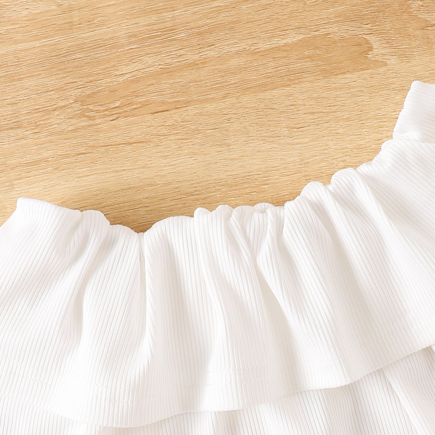 フリルが連なったVネック長袖トップスのネックラインディテール
