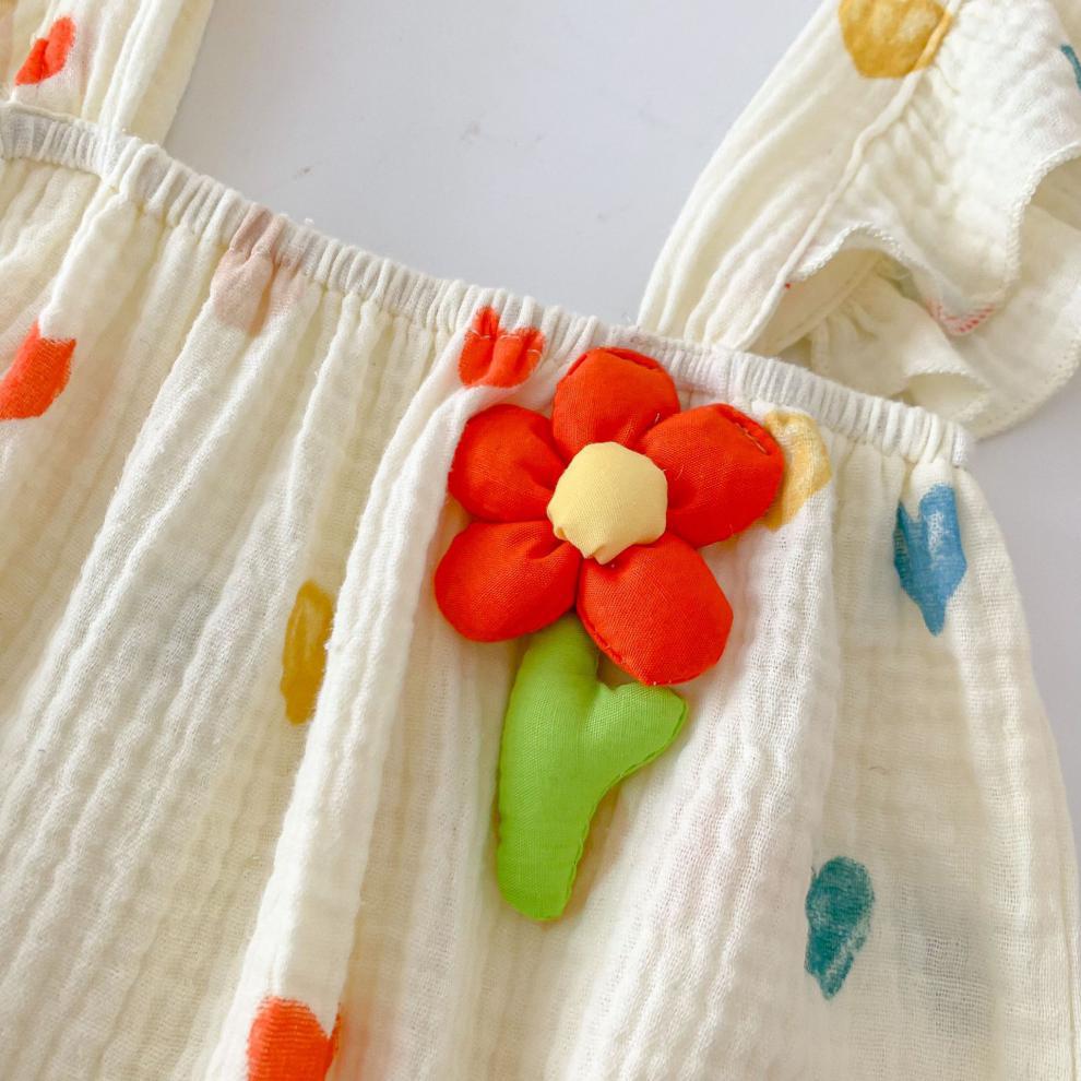 胸元の立体フラワー装飾が目を引くハート柄ベビーロンパースのアップ
