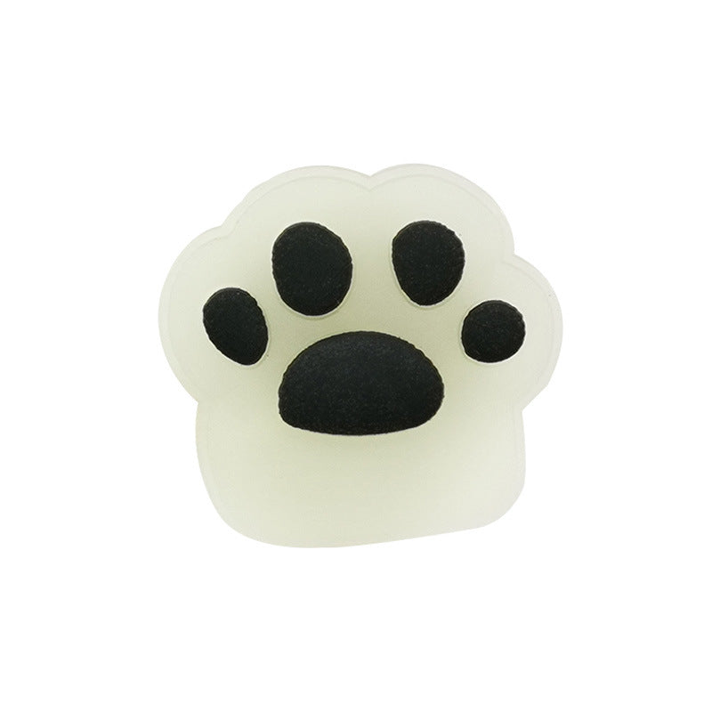 黒い肉球マークデザインのシューズチャームを白背景で撮影した画像
