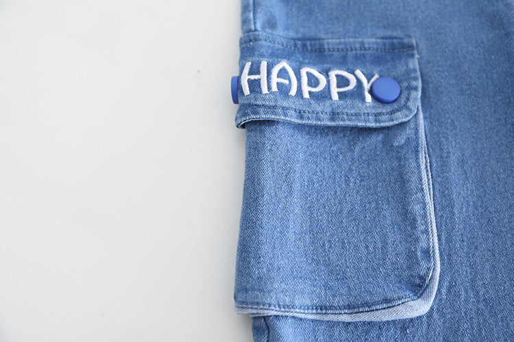 「HAPPY」の刺繍文字が入ったキッズ用デニムパンツ裾とポケット部分のクローズアップ
