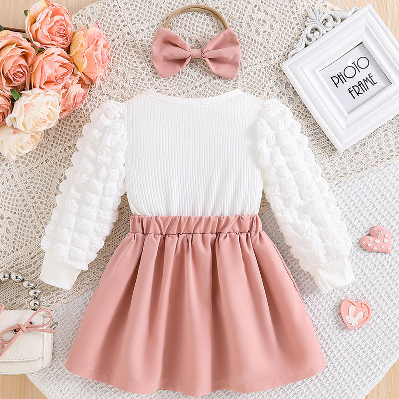 ピンクカラーのベビーワンピースを平置きした画像
