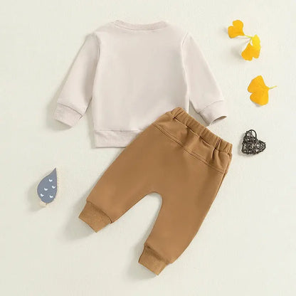 トップスの英字プリント部分のクローズアップ「MAMA’S LITTLE BESTIE」
