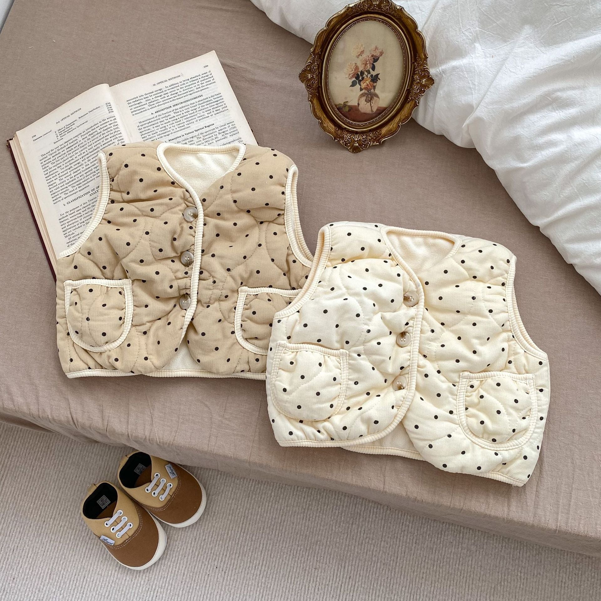 ベッドの上に並べられたドット柄コットンベビーベストカーキカラー
