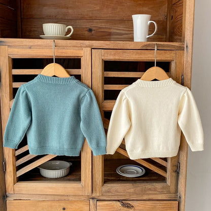 アプリコットとアーミーブルーの2色カーディガンを重ねて見せたコーディネートイメージ画像  
