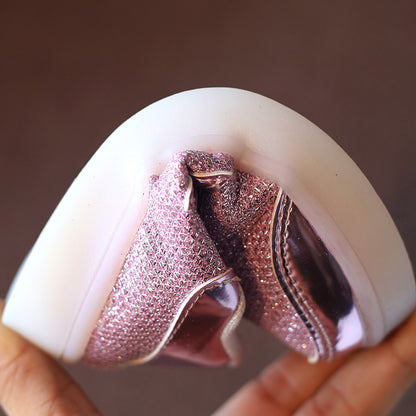 柔らかく曲がるソールを持つピンクのキッズスニーカーのクローズアップ
