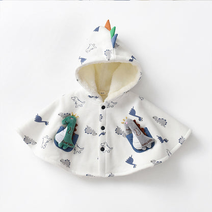 ダイナソー柄ベビーポンチョケープの生地の上に置かれた王冠付きグリーンダイナソーぬいぐるみのアップ画像
