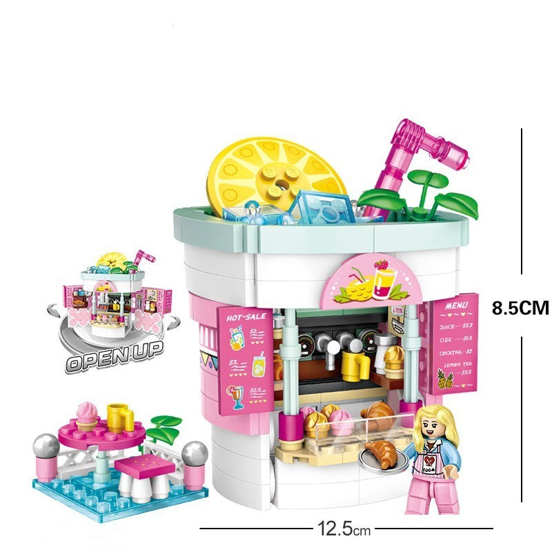 ピンクを基調としたジュースショップ風ミニブロックセット。レモンスライスの大きな看板、ブレンダー風パーツ、カウンター、ショーケース、ドリンクメニュー、テーブル席、人形フィギュア付きで細部まで再現。幅12.5cm×高さ8.5cmのコンパクトサイズで、知育遊びや創造力アップに最適なビルディングトイ。
