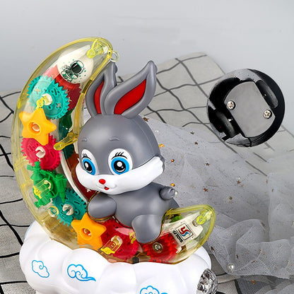 半月型の透明カバーの中でカラフルなギアが回転し雲の上にうさぎが座っている電動ムーンラビットトイの正面写真
