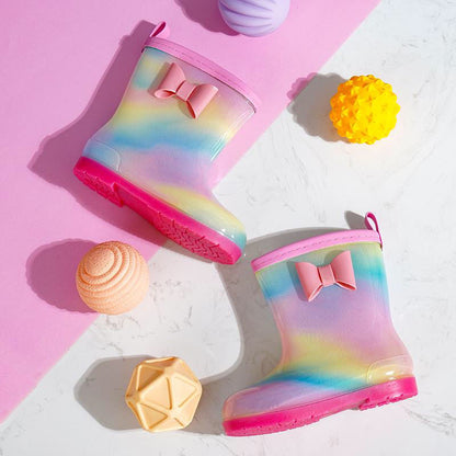白い背景にピンクのソールが映えるグラデーションレインボーベビーレインブーツを前後に並べた商品写真
