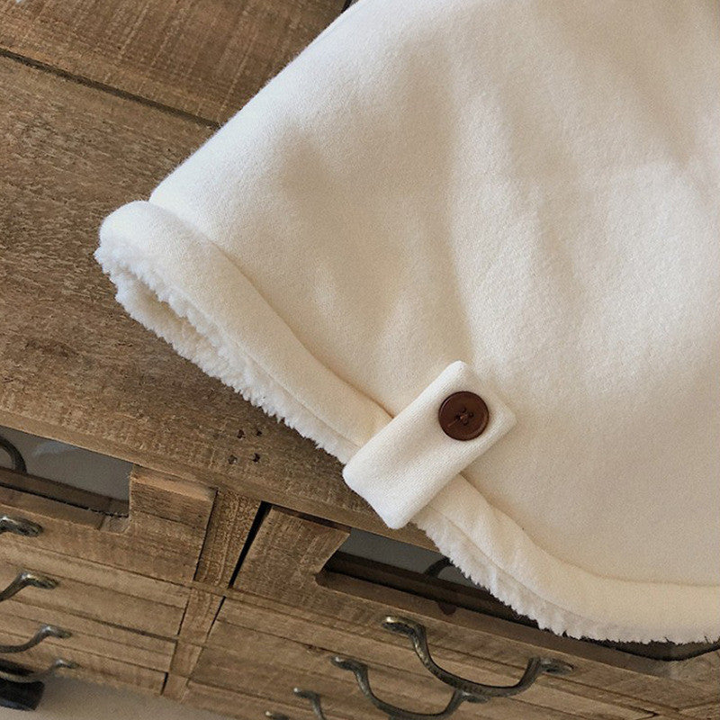 前ボタンと裾ラインのカーブが分かるキッズケープアウターのディテール画像
