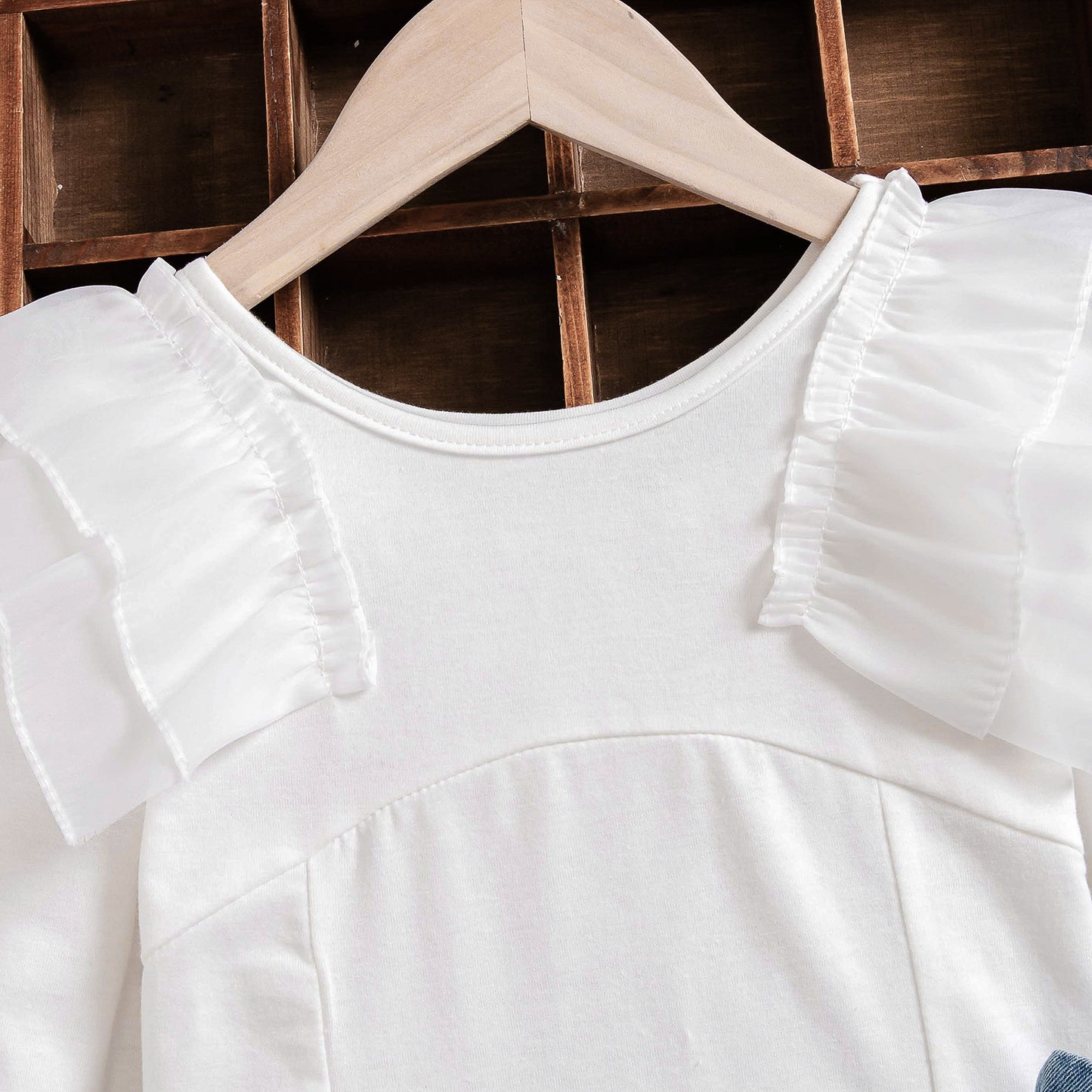 ハンガーにかけられたホワイト長袖トップスとスカートセットの正面画像
