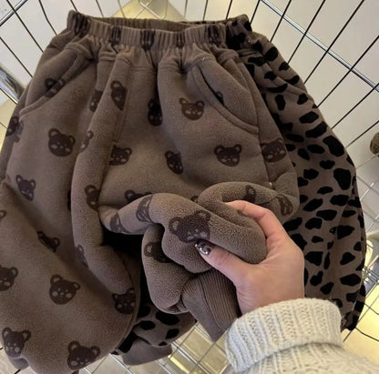 くま柄プリントの裏ボア子どもサルエルパンツを手に持って厚みを見せている画像
