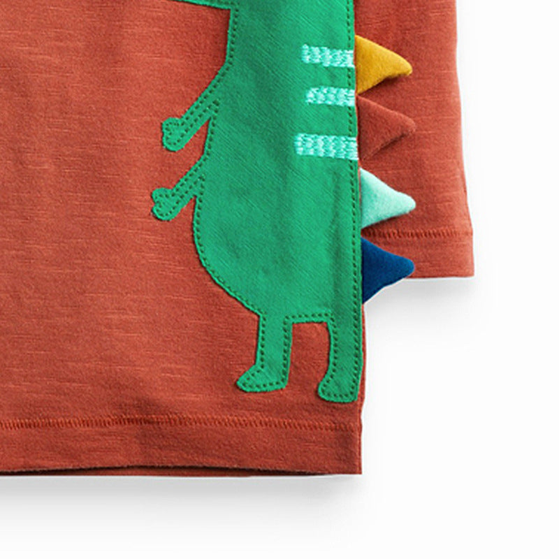 オレンジ長袖Tシャツのサイドに入った大きなワニプリントのクローズアップ
