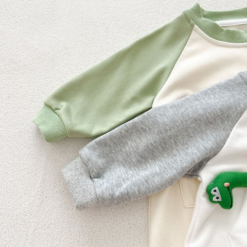 グリーンとグレーのラグランスリーブが並んだ長袖ベビーカバーオールの袖ディテール
