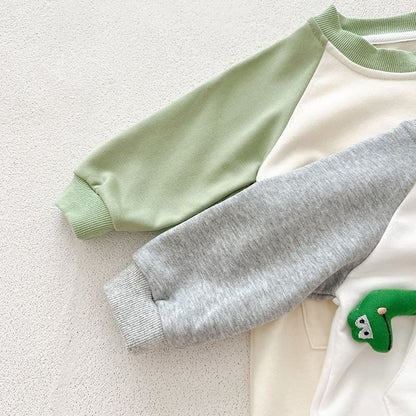 グリーンとグレーのラグランスリーブが並んだ長袖ベビーカバーオールの袖ディテール
