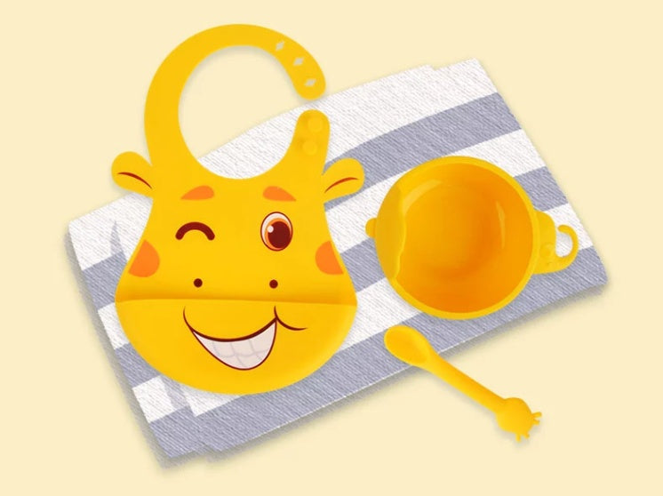 イエローのシリコンお食事セット ビブ・吸盤ボウル・スプーンを並べた写真（ベビー食器）
