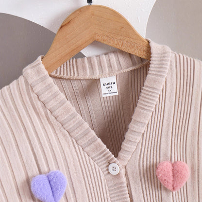 子ども用ハンガーにかけられたピンクスカート付きセットアップの正面画像
