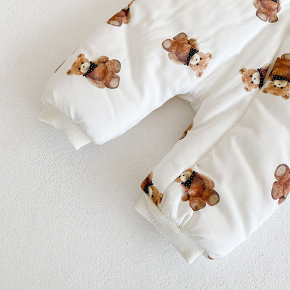 袖口と足元のリブカフスとくま柄プリントが見えるベビーカバーオール裾部分のクローズアップ
