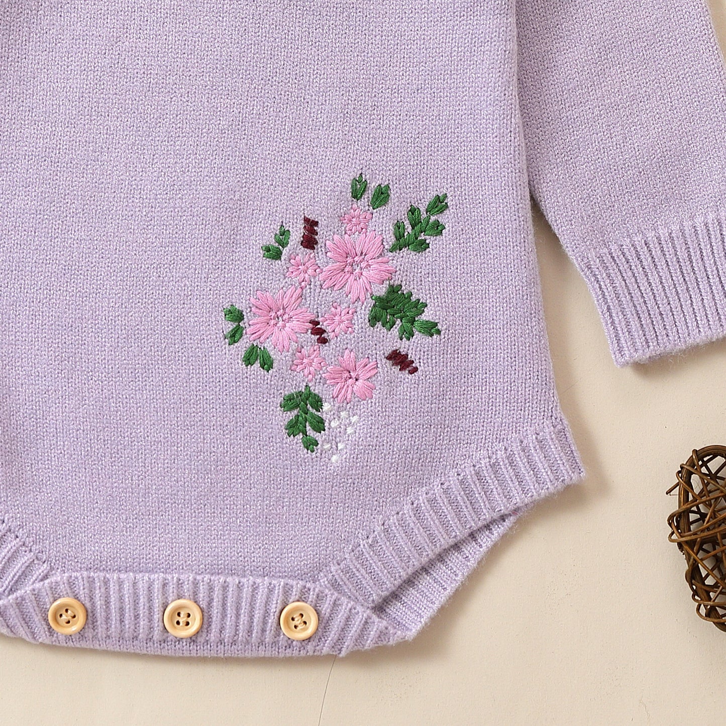 花刺繍のディテールがわかるラベンダーのベビーロンパース
