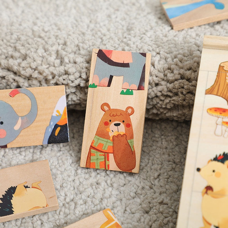 木製ドミノパズルのピースの接写。動物イラストが描かれた長方形ブロックがグレーのラグの上に散らばっている。