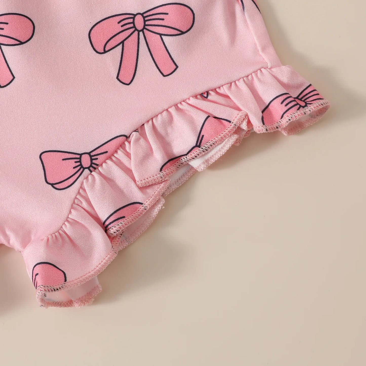 ショートパンツの裾フリルとリボン柄プリントのディテール
