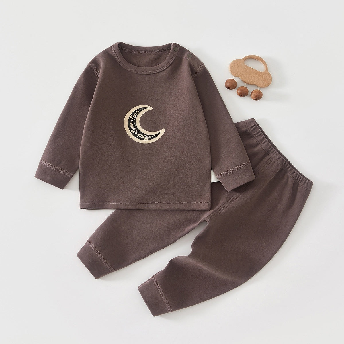 ダークブラウンの長袖トップス胸元に月モチーフプリントが入ったロングパンツ合わせのコットンベビーパジャマセット
