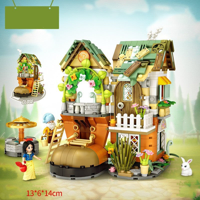 童話風のミニブロックセット。苔むした緑の三角屋根、木枠の大きな窓、白いアーチ玄関、石造りの土台、花壇や植物の装飾、きのこ型パラソル、石井戸、フェンス付きバルコニー、野原の背景、ウサギと女性フィギュア付き。細部まで作り込まれたデザインで想像力・集中力・空間認識力を育てる知育ビルディングトイ。サイズ13×6×14cm。
