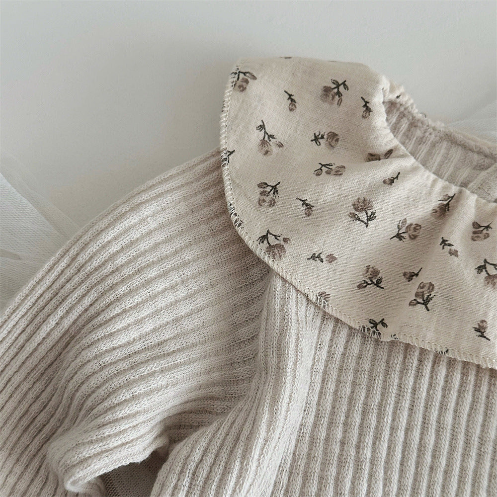 襟のフリル部分に小さな花柄があしらわれたベビー長袖トップスのクローズアップ
