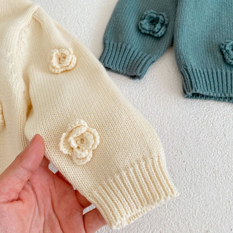 木製チェアの背もたれに掛けられたアーミーブルーベビーニットカーディガンの雰囲気ある画像  
