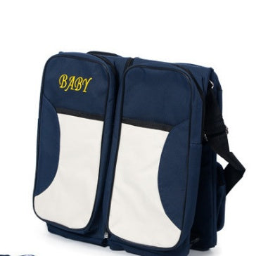 前面ポケットにイエローで「BABY」と刺繍されたネイビー×ベージュのママバッグ一体型ベビーベッドを閉じた状態で写した写真（ネイビーマザーズバッグ）
