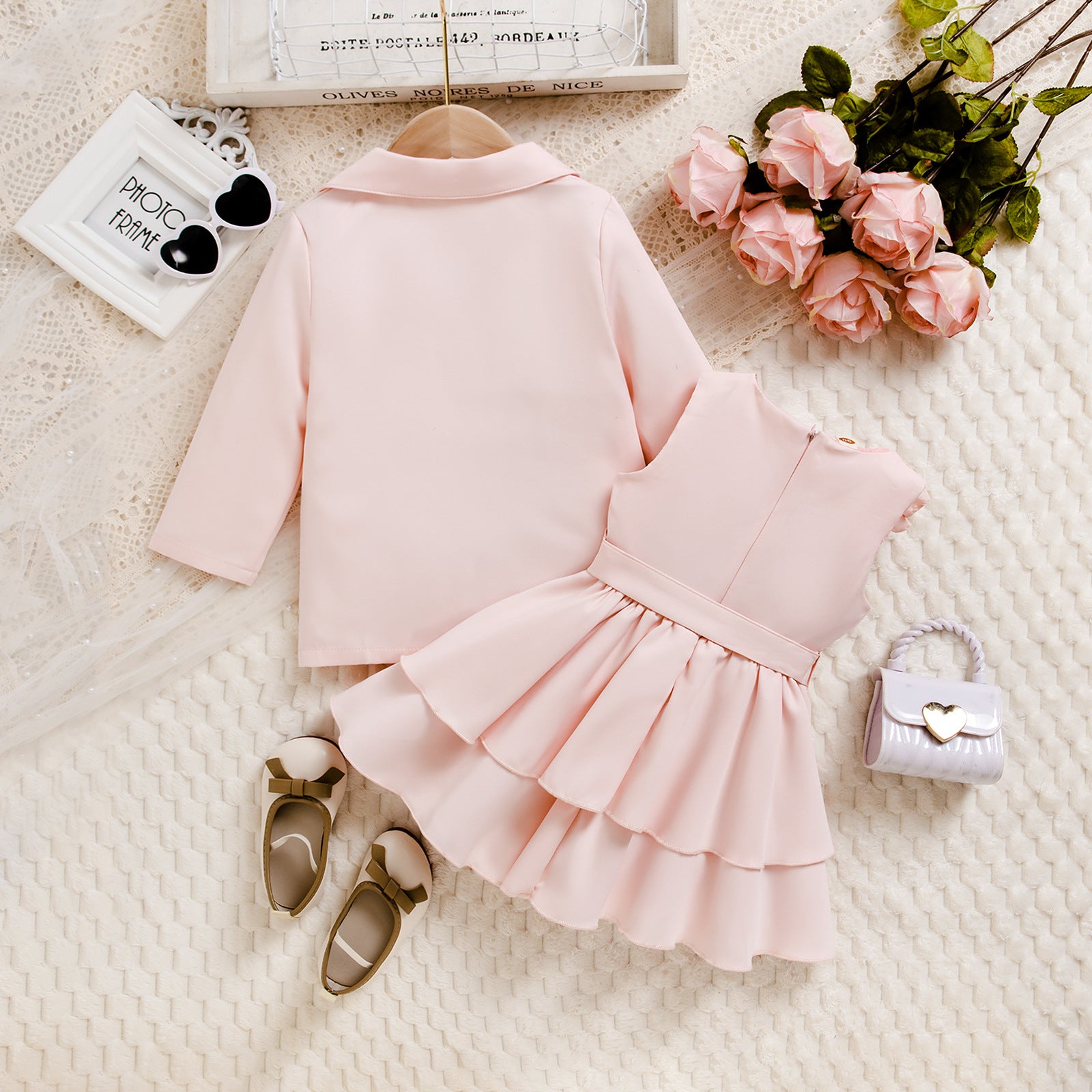 ピンクワンピースとコートにサンダルを合わせた女の子フォーマルコーデのフラットレイ
