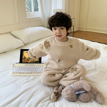 ベージュのふわもこパジャマを着た子どもがやわらかなブランケットを抱えてベッドの端に座っているシーン
