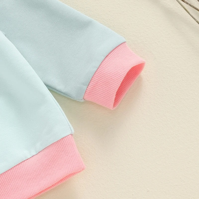 袖口と裾のピンク配色が分かる長袖トップスのディテール
