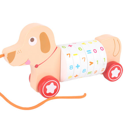 丸い車輪と数字入りの胴体を持つベージュ色の木製イヌ型プルトイが横から見える画像
