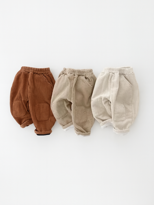 重ねて並べられた3色のコーデュロイベビーパンツのボリューム感がわかるイメージ写真
