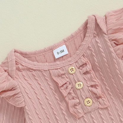 胸元にフリルと木調ボタンが並んだピンクニットベビー長袖トップスのディテールアップ

