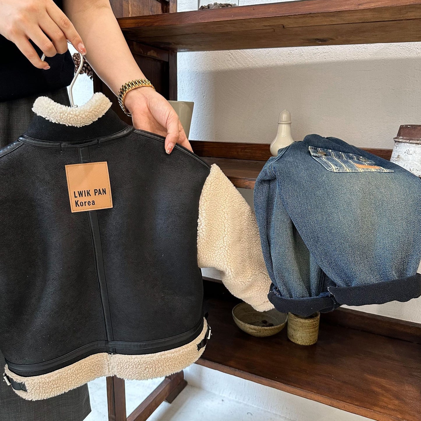 ブラックの切り替えボアジャケットを前開きにしてインナーを見せたコーディネート画像
