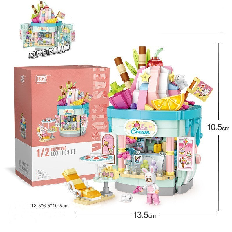 アイスクリーム＆ドリンクテーマのショップ型ミニブロックセット。大きなシェイクやレモンスライスのデコレーション、パステルブルーの店舗、ピンクの看板、カウンター、ドリンクマシン、アイスケース、テラス席、サマーチェア、小物アクセサリー、うさぎフィギュア付き。創造力・集中力・空間認識力を育てる知育ビルディングトイ。幅13.5cm×高さ10.5cm。
