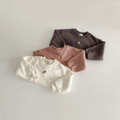 グレーとピンクとオフホワイトの子ども用トレーナーを並べた写真
