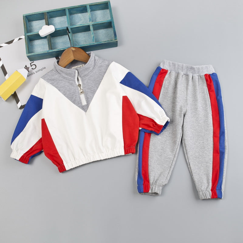 レッドとブルー配色トップスとグレー長ズボンの男の子用スポーツセットアップコーデ
