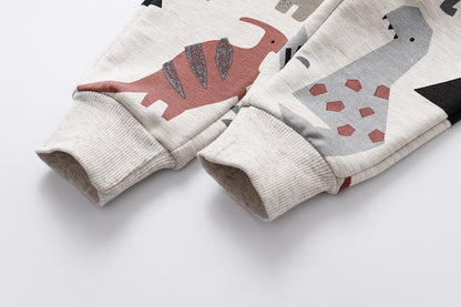 明るい背景の上に平置きされたカラフルな恐竜プリントキッズパンツ
