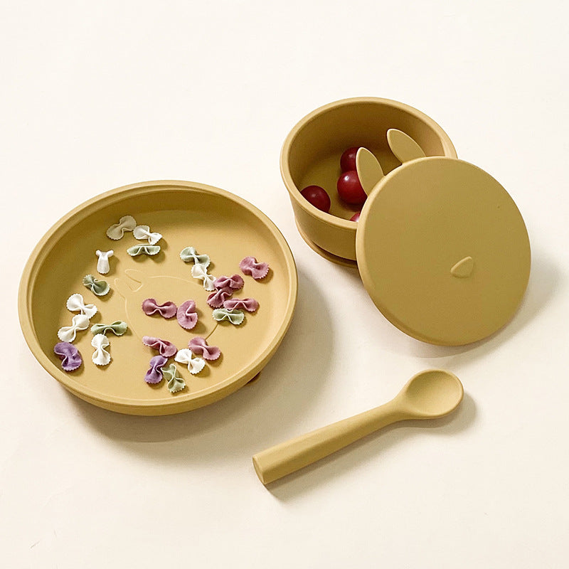 マスタードカラーのシリコンベビーボウルとプレートとスプーンにおやつを盛り付けた画像（シリコンベビー食器セット）
