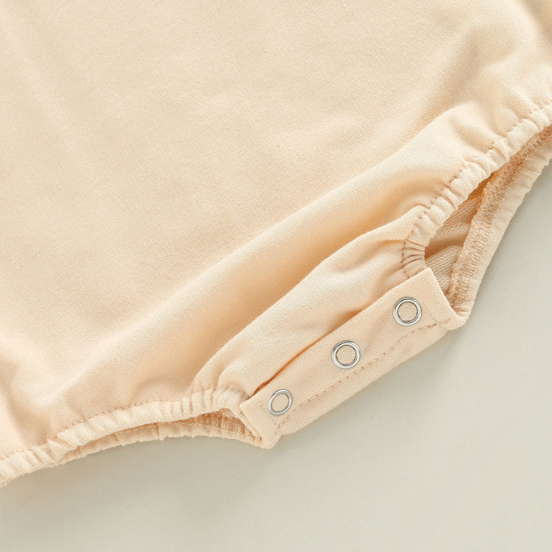 コーヒー色とオフホワイトのロンパースを並べたフラットレイ
