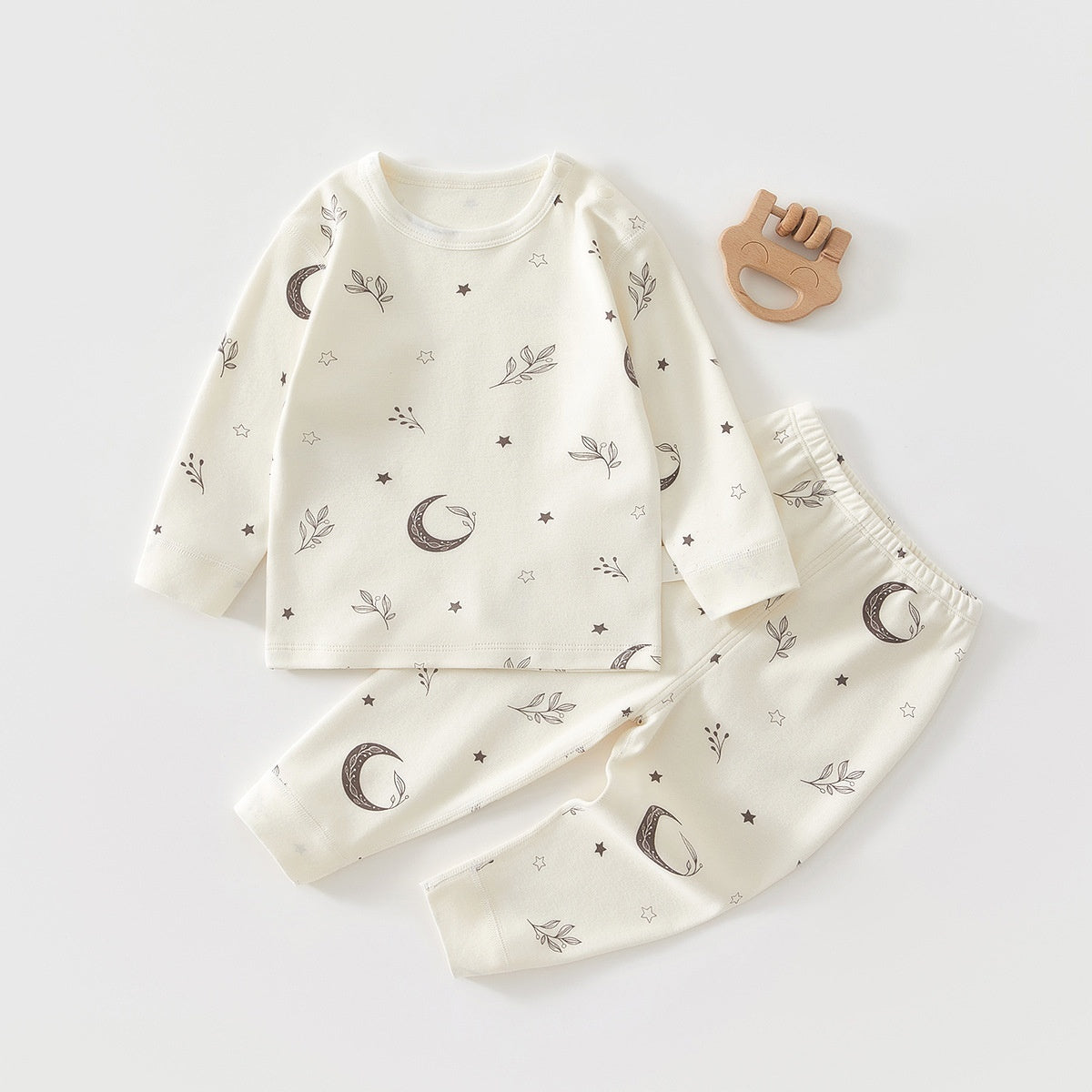 ホワイト地に淡いトーンの三日月柄が散りばめられた長袖トップスとロングパンツのコットンベビーパジャマセット
