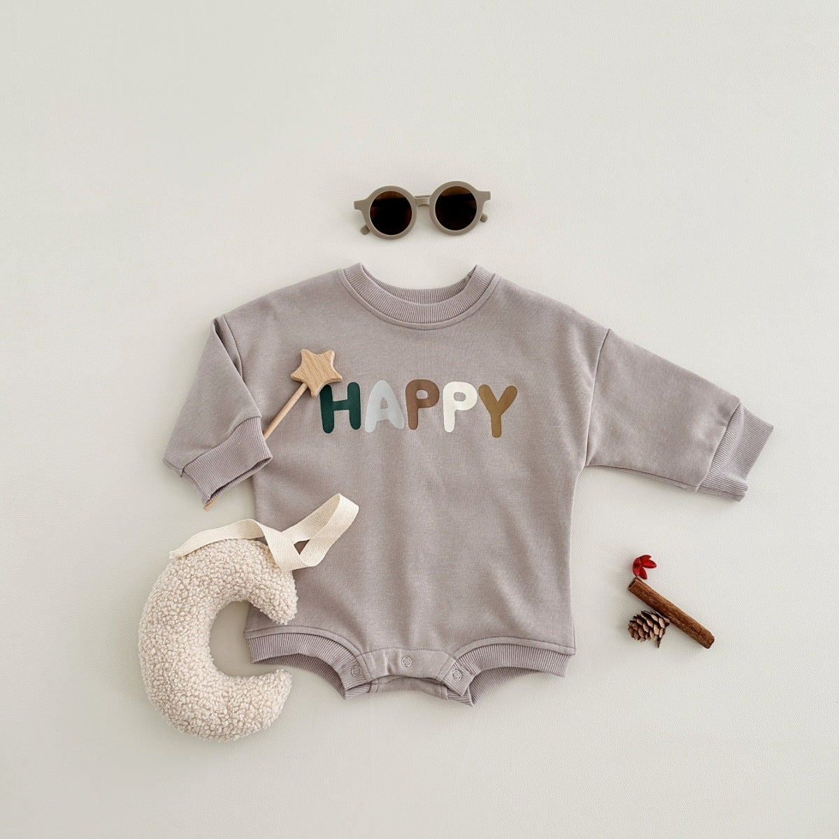 冬の小物と合わせて並べたベビーボディスーツのフラットレイ写真
