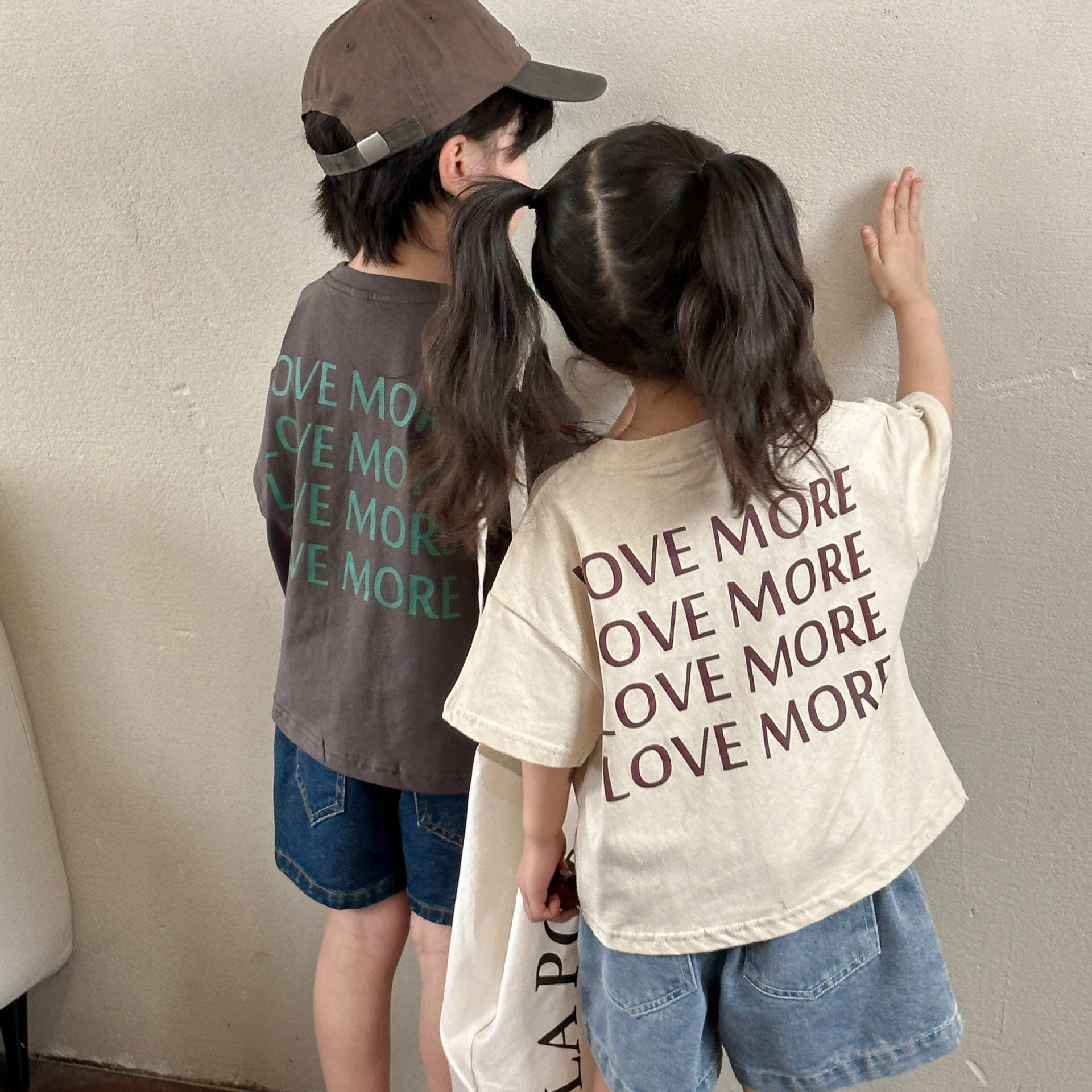背面のLOVE MOREプリントが見える子ども半袖Tシャツの着用イメージ
