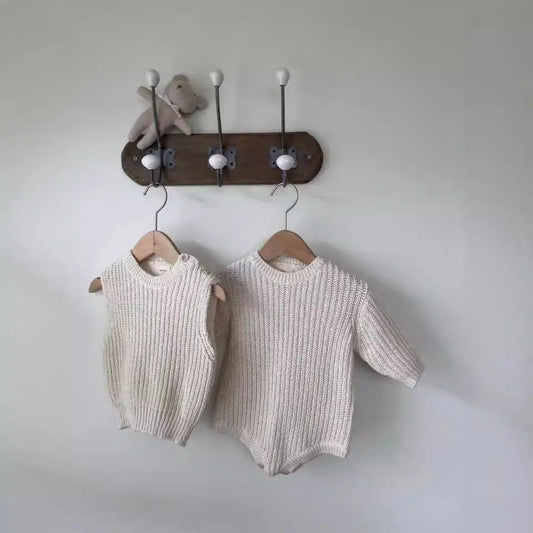 ベージュとコーヒーカラーのロンパースを並べたフラットレイ構図
