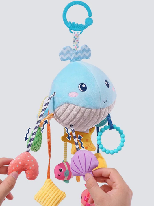 クジラデザインのハンギングトイ全体と触れる手元（ベビーカーおもちゃ）
