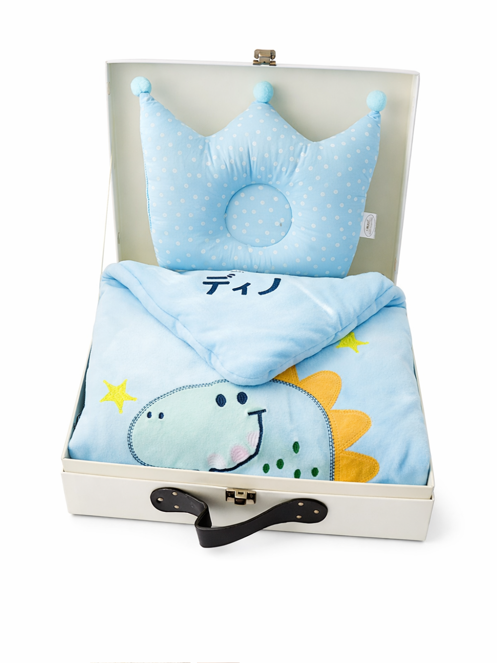 ベビー用寝具セット（淡いブルーの王冠型枕と恐竜柄ブランケット）を開いたスーツケースに収めた商品写真、白背景。
