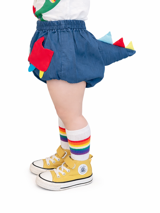 恐竜のしっぽが付いたブルーのデニムショートパンツを着用した後ろ姿
